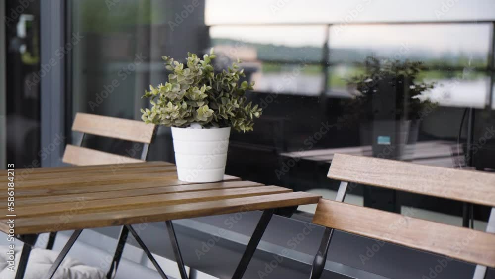 A small table with a pair of chairs on a balcony - closeup A small table with a pair of chairs on a balcony - closeup