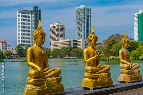 Golden buddha statues at Gangarama Seema Malakaya buddhist temple at Colombo, Sri Lanka photo