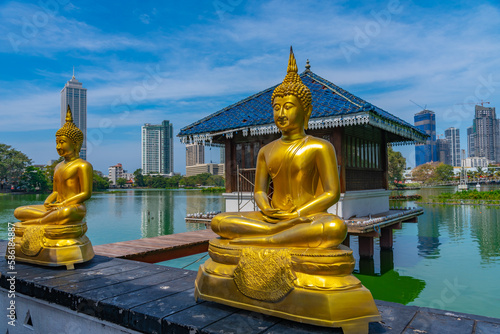 Golden buddha statues at Gangarama Seema Malakaya buddhist temple at Colombo, Sri Lanka photo