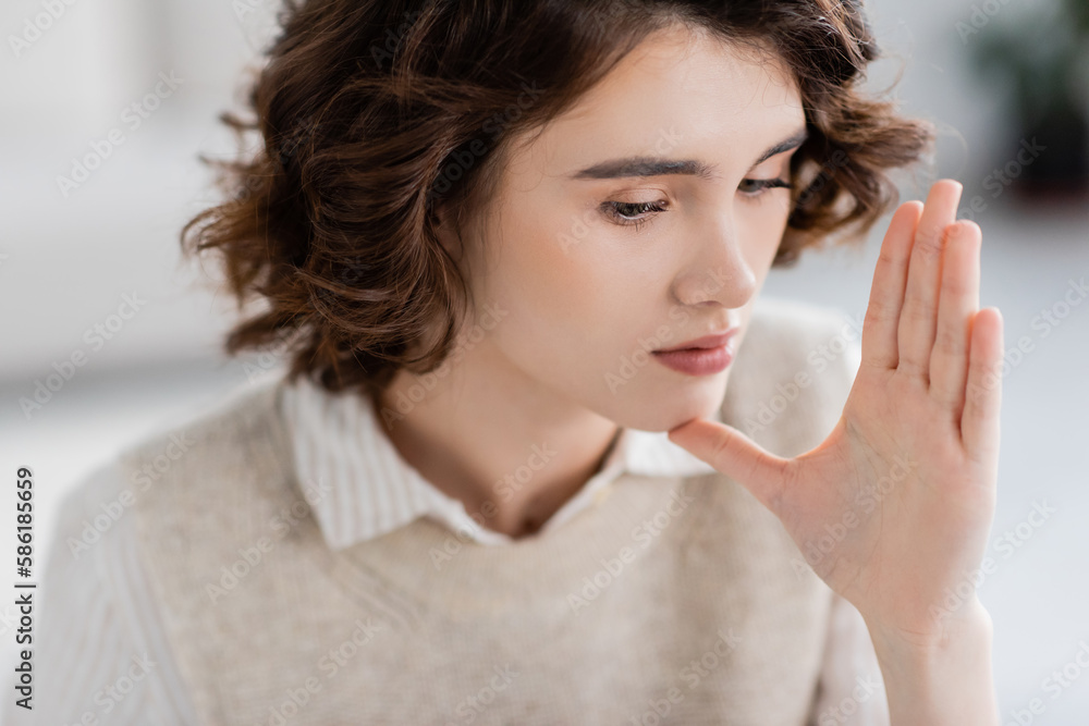 portrait of young brunette woman showing mother or woman gesture on sign language. portrait of young brunette woman showing mother or woman gesture on sign language.