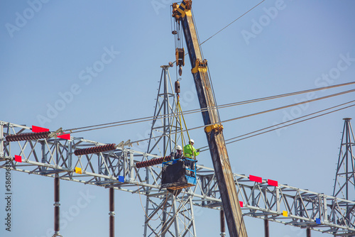 Wallpaper Mural Male workers Installation of high-voltage transmission electricity poles on the crane Torontodigital.ca