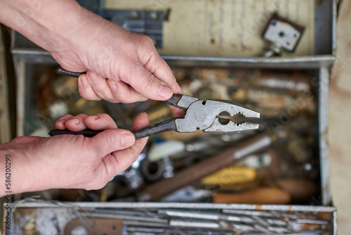 The master holds pliers in his hands