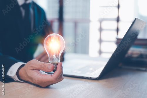 ideas inspiration concept, businessman with illuminated light bulb, working on laptop at office, concept for idea, innovation and inspiration in business, business opportunities