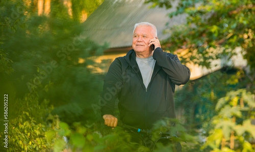 portrait of an elderly man with a smartphone with a serious and joyful emotion