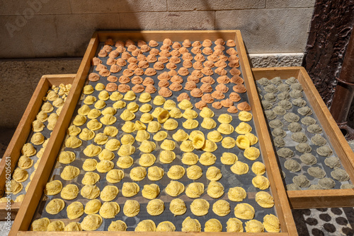 Exposure of the famous Apulian orecchiette, a type of fresh handmade pasta on the street by housewives in Bari Vecchia, Apulia, Italy. photo