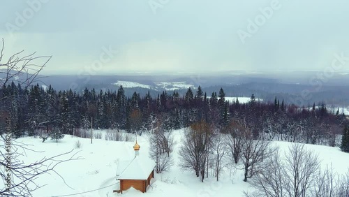 View of the chapel near the Belogorsky St. Nicholas Orthodox Missionary Monastery. Winter forest. The temple on the hill in winter. Russia, Perm Krai, Belaya Gora. 4K photo