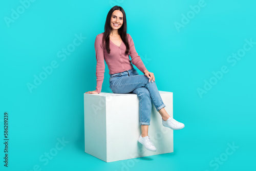 Full body portrait of stunning satisfied lady sitting podium toothy smile isolated on turquoise color background