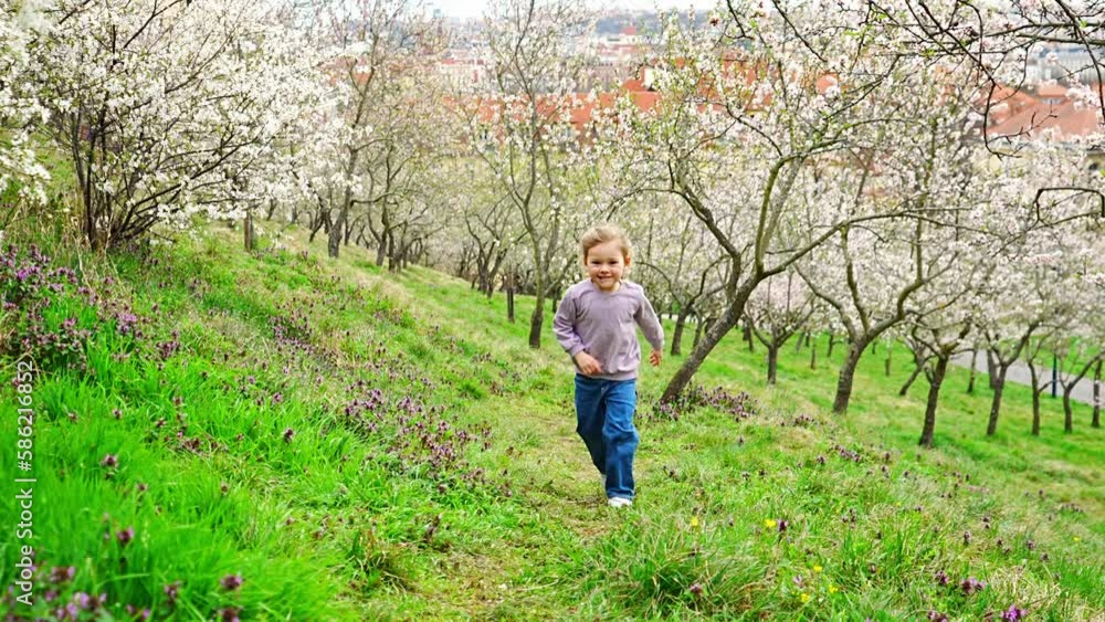 Happy little girl run and hav a fun in spring park in sunny day in Prague, Europe Happy little girl run and hav a fun in spring park in sunny day in Prague, Europe