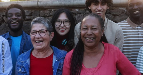 Group of multigenerational people smiling in front of camera - Multiracial friends with different ages having fun together at city park 