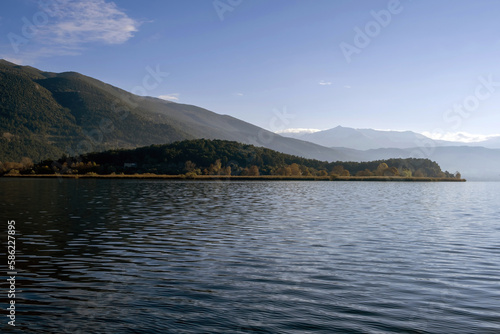 Greece, Pamvotis Lake, Ioannina city Epirus. Giannena nisaki, dark calm water, blue sky background.