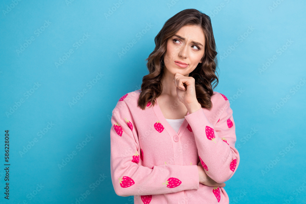 Photo portrait of pretty dreamy funny girl touch chin thoughtful looking empty space unsure bad product high price isolated on blue color background Photo portrait of pretty dreamy funny girl touch chin thoughtful looking empty space unsure bad product high price isolated on blue color background