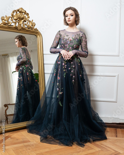 A woman in a black dress with flowers on the front photo