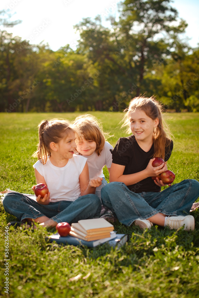 happy children play and have break in park after school classes on green trees background happy children play and have break in park after school classes on green trees background
