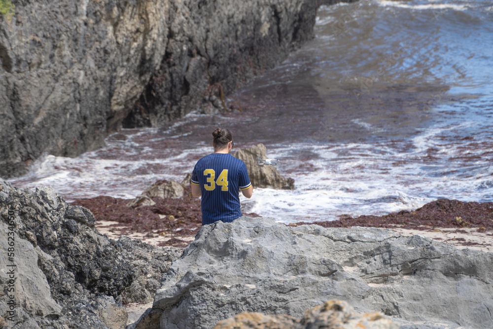 Young man climbing a rock in the mountains