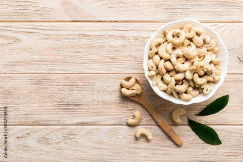 cashew nuts in wooden bowl on table background. top view. Space for text Healthy food