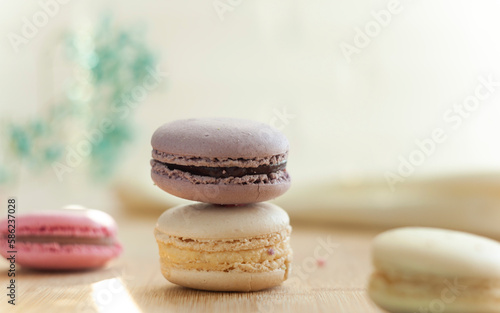 Fototapeta Naklejka Na Ścianę i Meble -  Selective focus. Macaroons stand in a column. Close up shot of food. French dessert. Multifaceted photo. Photo taken with an old Helios 44 lens.