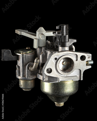 Carburetor, part of a gasoline internal combustion engine, spare part, isolated on a black background