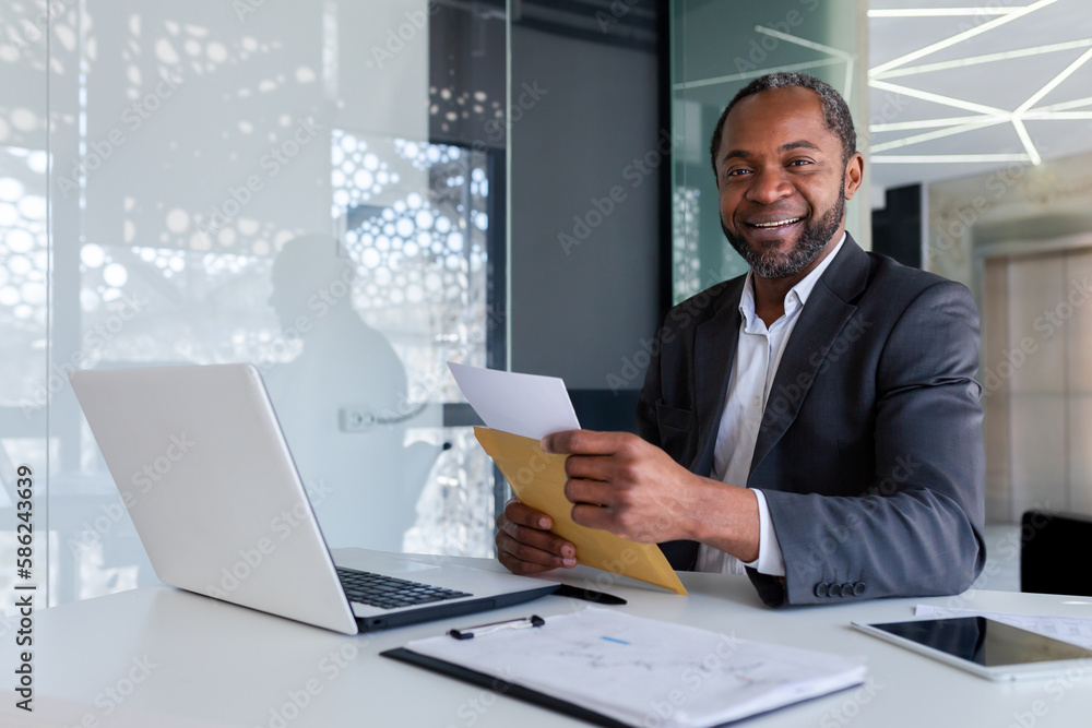Portrait of successful african american businessman financier at workplace inside office building, male mature adult smiling and looking at camera, boss received mail envelope message. Portrait of successful african american businessman financier at workplace inside office building, male mature adult smiling and looking at camera, boss received mail envelope message.