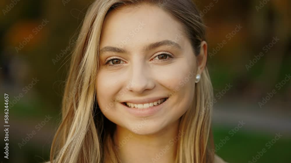 Close Up Portrait of Smiling Caucasian Woman while Standing in the Street. Happy Young Lady Enjoys Life. Beautiful Girl Looking With Love in Sunset Light Outdoor Close Up Portrait of Smiling Caucasian Woman while Standing in the Street. Happy Young Lady Enjoys Life. Beautiful Girl Looking With Love in Sunset Light Outdoor