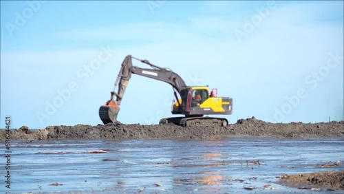 Excavator works on the nourishment of the sandy coast