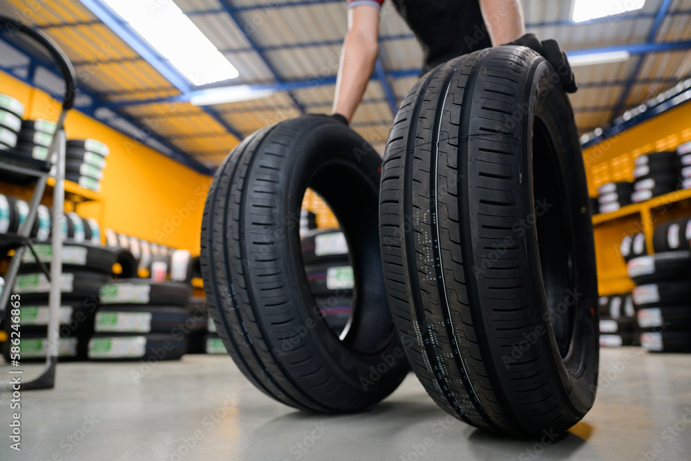 A tire changer checks new tires in stock to take them to a service center or wheel shop. Tire warehouse for the automobile industry A tire changer checks new tires in stock to take them to a service center or wheel shop. Tire warehouse for the automobile industry