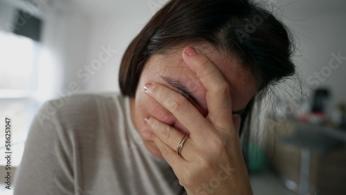 One anxious woman suffering from mental problems and anxiety at home indoors. Extreme close up of lonely guilty female person feeling despair