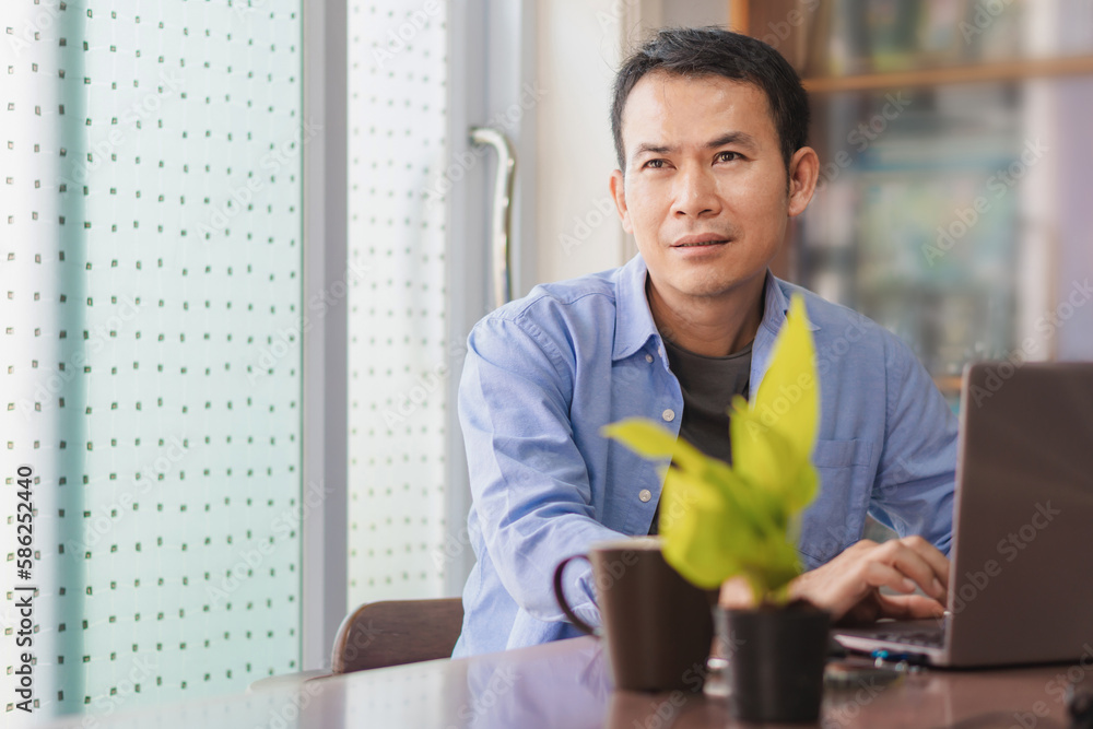 Asian man using laptop at home, Male hands typing on the notebook keyboard, Working from home concepts Asian man using laptop at home, Male hands typing on the notebook keyboard, Working from home concepts