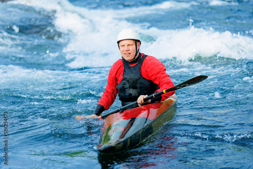 Portrait kayaker of smiling man in kayak boat background blue water