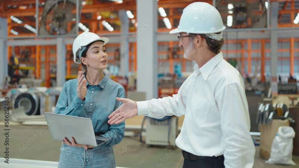Two engineer manager leader and woman assistant holding laptop and shaking hands for making together after processes order at metal factory Two engineer manager leader and woman assistant holding laptop and shaking hands for making together after processes order at metal factory