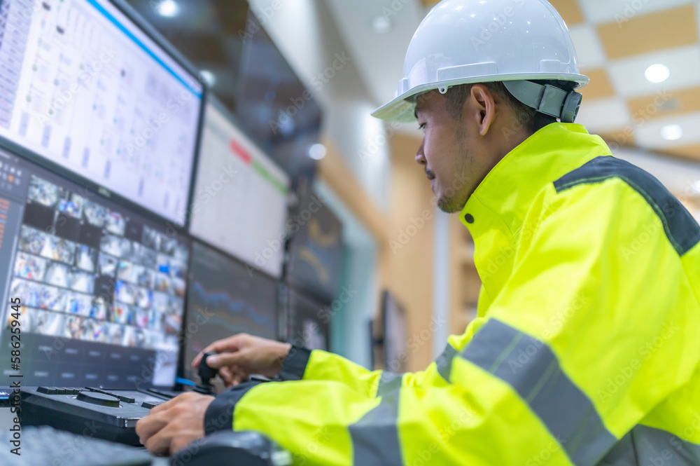 Engineer working at control room,Manager control system,Technician man monitoring program from a lot of monitor Engineer working at control room,Manager control system,Technician man monitoring program from a lot of monitor