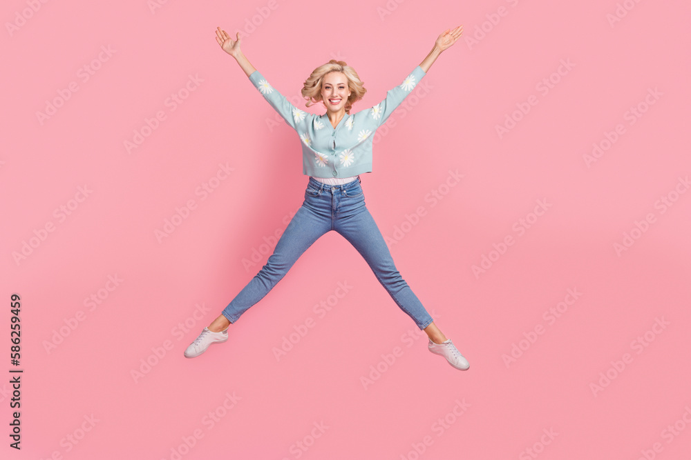 Full length photo of sweet adorable lady dressed flower print cardigan jumping high like star isolated pink color background Full length photo of sweet adorable lady dressed flower print cardigan jumping high like star isolated pink color background