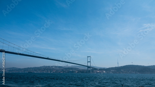 View of Bosphorus bridge, opposite coast and tour boat from Ortakoy coast in Istanbul Turkey. 