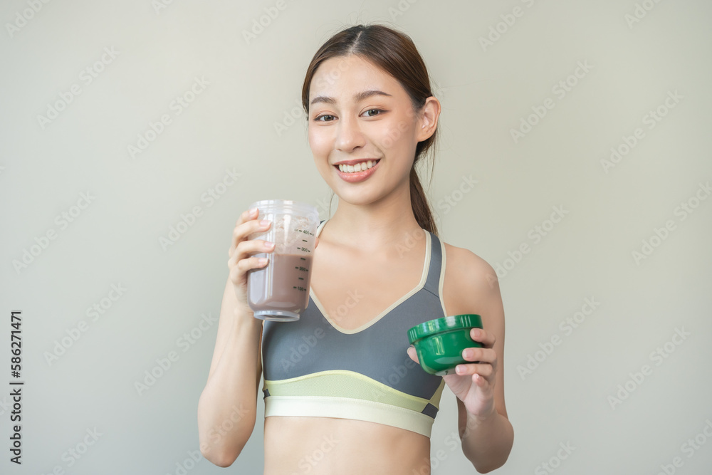 Diet meal replacement for weight loss, smile asian young woman, girl in sportswear, hand in holding protein shake bottle for drink supplement for muscle after workout at home. Healthy body care person Diet meal replacement for weight loss, smile asian young woman, girl in sportswear, hand in holding protein shake bottle for drink supplement for muscle after workout at home. Healthy body care person