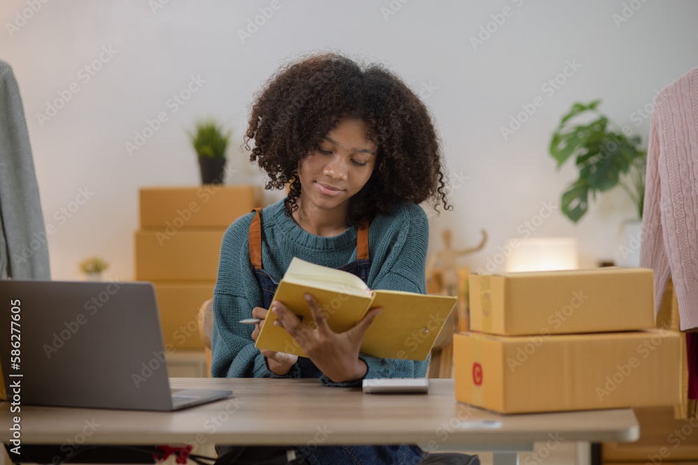 Young African American woman and online selling at home office, Startup small business owner working Online selling and product order for delivery to customer. Young African American woman and online selling at home office, Startup small business owner working Online selling and product order for delivery to customer.