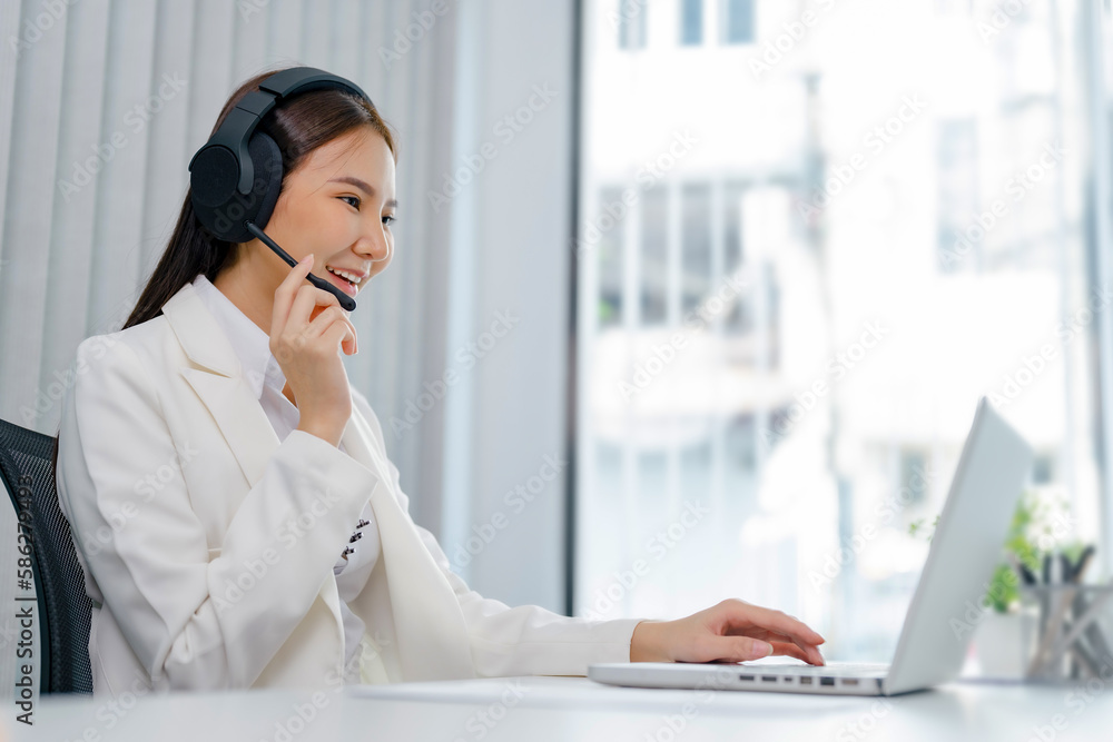 Smiling customer support service operator help desk. Young operator asian woman agent with headsets working support hotline in a call centre Smiling customer support service operator help desk. Young operator asian woman agent with headsets working support hotline in a call centre