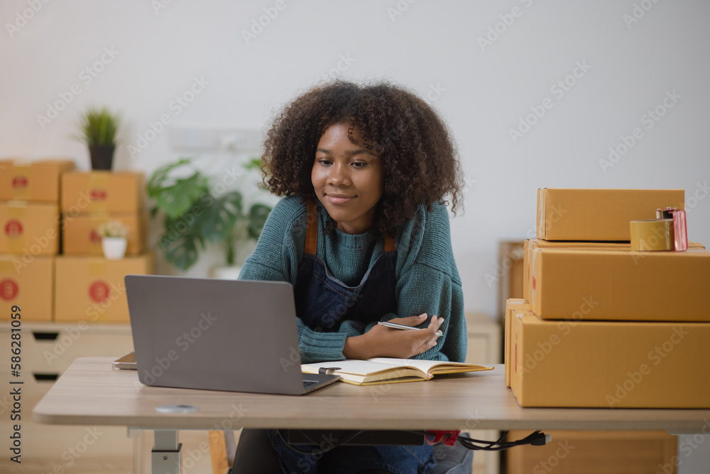 Young African American woman and online selling at home office, Startup small business owner working Online selling and product order for delivery to customer. Young African American woman and online selling at home office, Startup small business owner working Online selling and product order for delivery to customer.