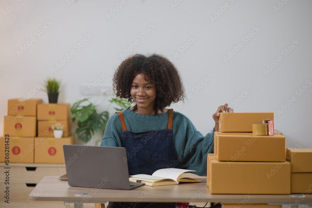 Young African American woman and online selling at home office, Startup small business owner working Online selling and product order for delivery to customer. Young African American woman and online selling at home office, Startup small business owner working Online selling and product order for delivery to customer.