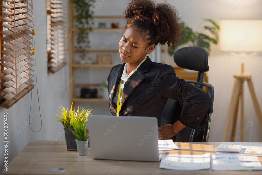 Young African American businesswoman working on laptop with documents and stressed over worked from work in the office, Overworked woman concept. Young African American businesswoman working on laptop with documents and stressed over worked from work in the office, Overworked woman concept.