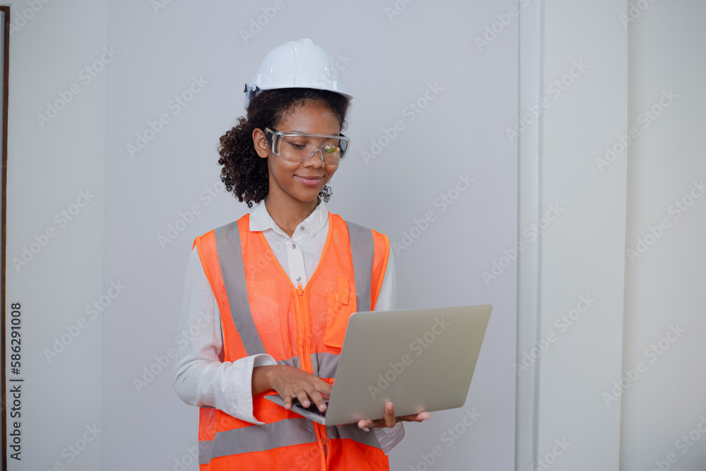 Engineering African American businesswoman holding digital tablet and computer in hands. African American woman builder using touchpad, Constuction, Engineering African American businesswoman holding digital tablet and computer in hands. African American woman builder using touchpad, Constuction,