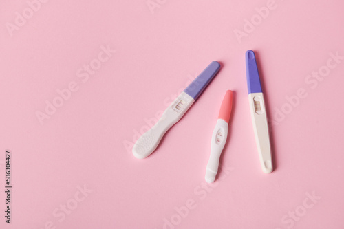 Top view of inkjet pregnancy test kits with a biochemical reaction between hCG and urine appearing in two bars, isolated pink color background. Ovulation day. Planning maternity. Gynecological concept