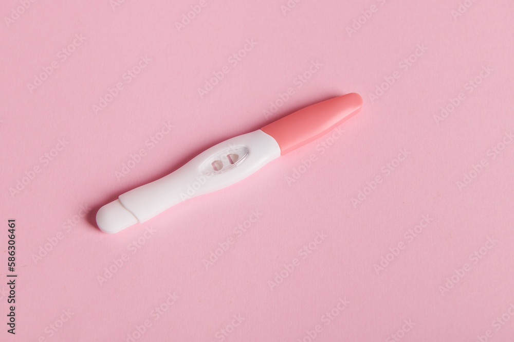 Positive inkjet pregnancy test kit on pink color background. Rapid diagnosis of pregnancy at home. Copy advertising space. Women's health. Ovulation date calculation. Planning pregnancy and maternity Positive inkjet pregnancy test kit on pink color background. Rapid diagnosis of pregnancy at home. Copy advertising space. Women's health. Ovulation date calculation. Planning pregnancy and maternity