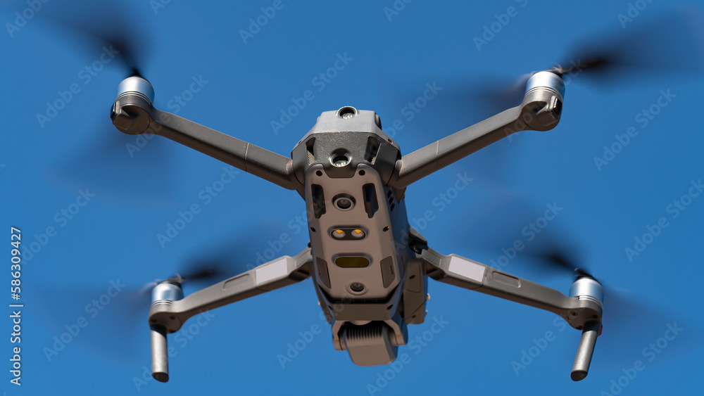 A flying mini drone recording video and photos in the sky over construction A flying mini drone recording video and photos in the sky over construction