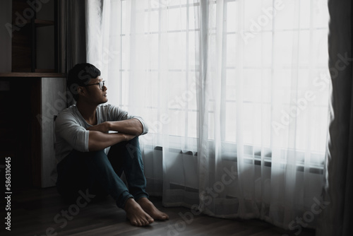 Sad young man sitting in the bedroom, People with depression concept, stressed man, 