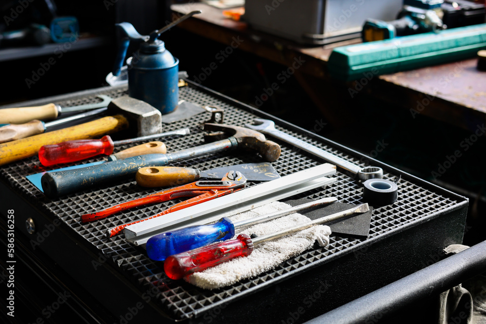 set of DIY equipment tools on manual  work station in garage workshop background.