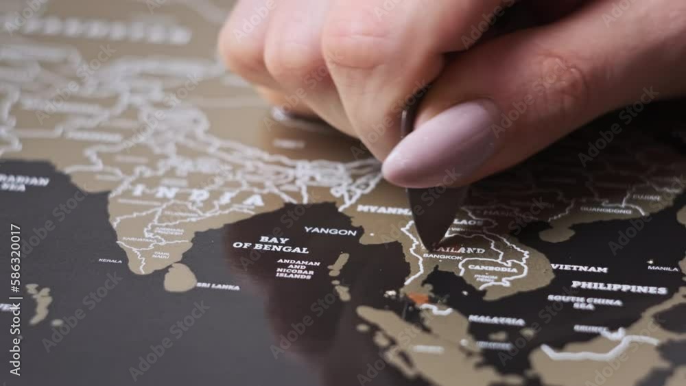 Scratching Thailand Country on the Surface of Scratch World Map. Woman