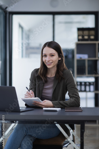 Happy excited young successful business woman and working online at the table in office, 