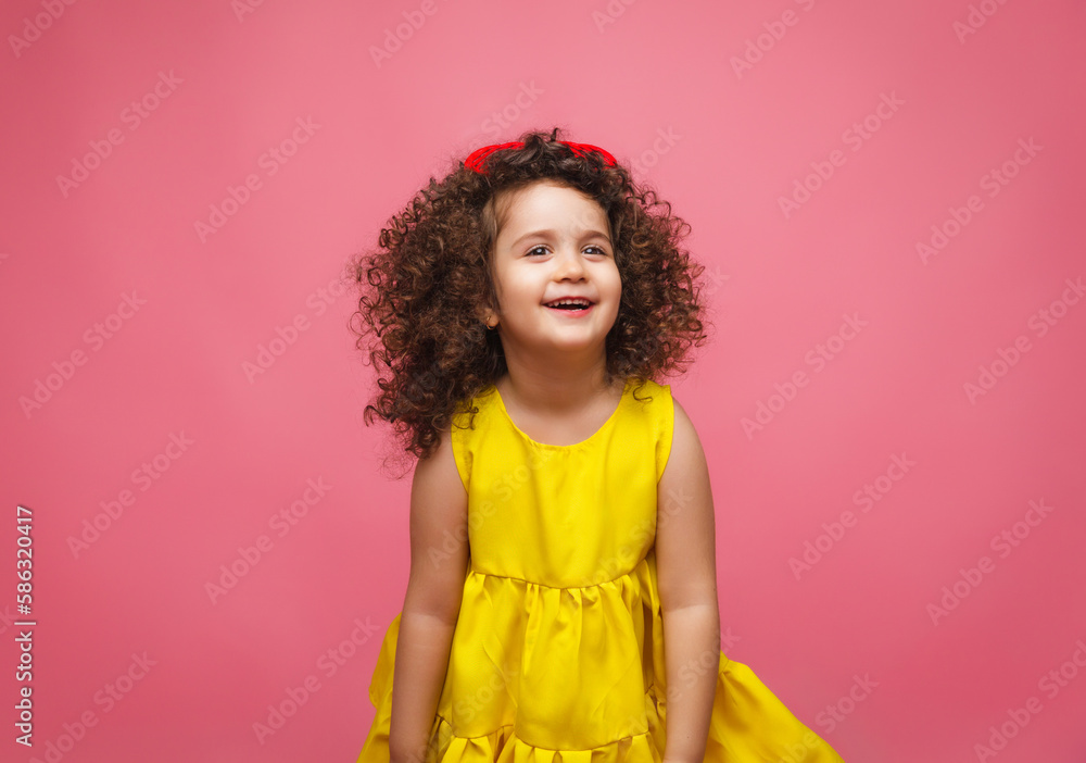portrait of a girl in a yellow dress cute attractive cute cheerful cheerful little girl .isolated pink background. portrait of a girl in a yellow dress cute attractive cute cheerful cheerful little girl .isolated pink background.