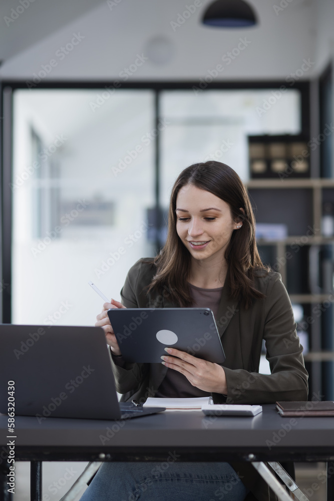 Happy excited young successful business woman and working online at the table in office, Happy excited young successful business woman and working online at the table in office,