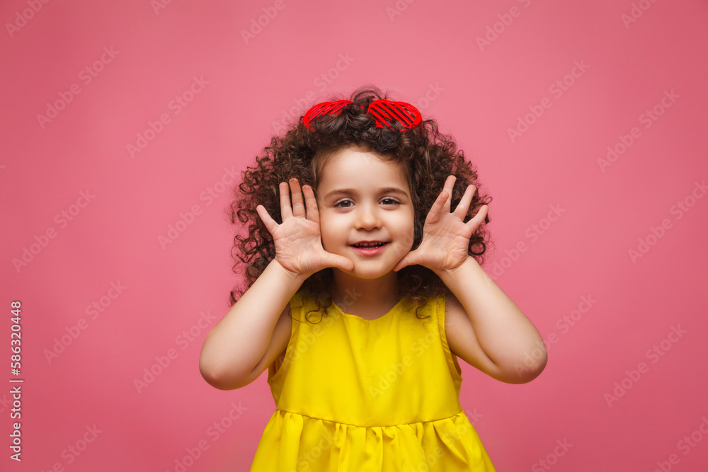 portrait of a girl in a yellow dress cute attractive cute cheerful cheerful little girl .isolated pink background. portrait of a girl in a yellow dress cute attractive cute cheerful cheerful little girl .isolated pink background.