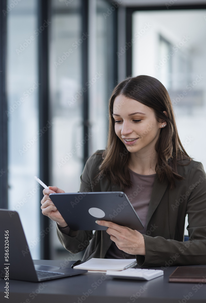 Happy excited young successful business woman and working online at the table in office, Happy excited young successful business woman and working online at the table in office,